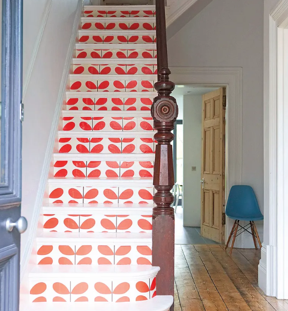 Brightly wallpapered stairs with a big red floral pattern on the front of every step