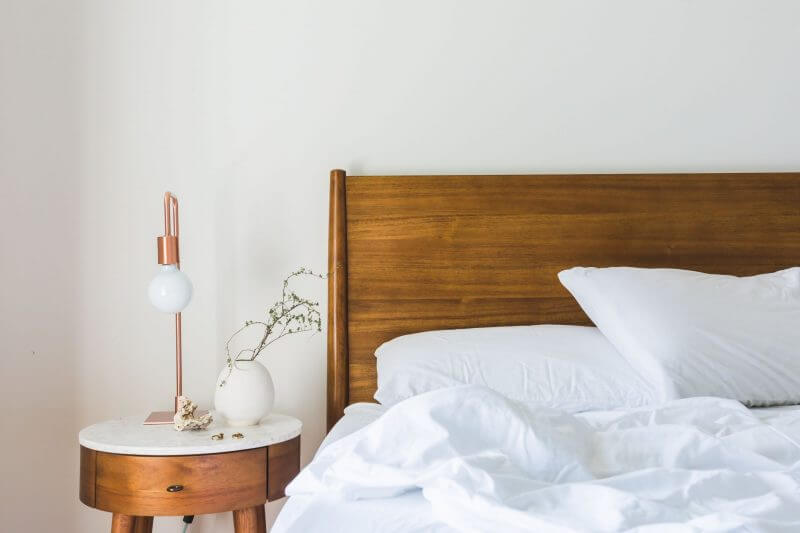 white bedding and white walls with wooden headboard