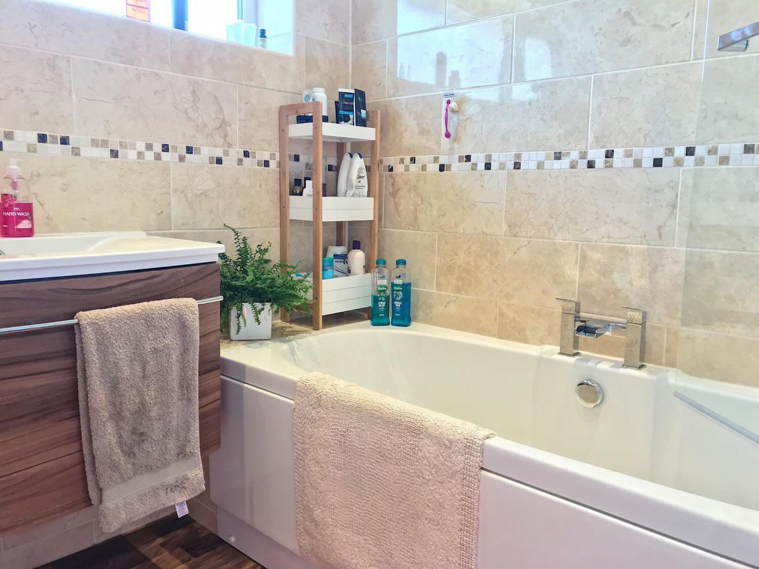 Our bathroom with bath, sink and plant