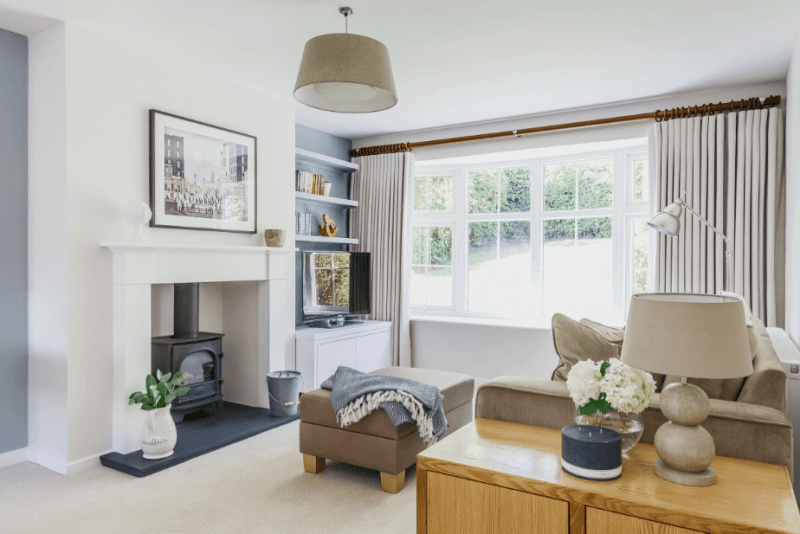 Log burner in a bright white living room.