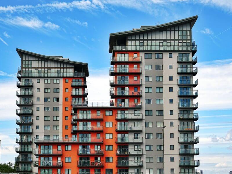 Moving from flat to house. Picture of large building of flats with balconies.