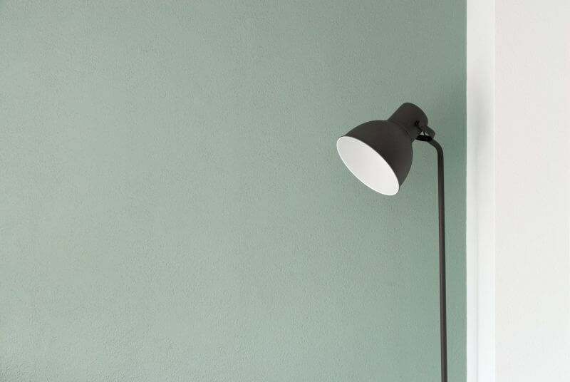 The cost of running a home - lamp switched on against a sage green wall