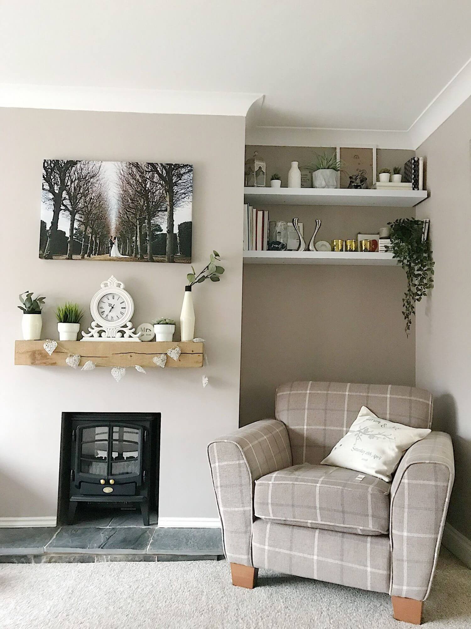 Full shelves with an armchair below and a wood mantelpiece