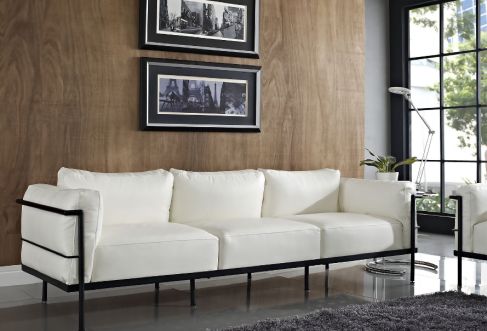 White sofa with black frame against a wood effect wall