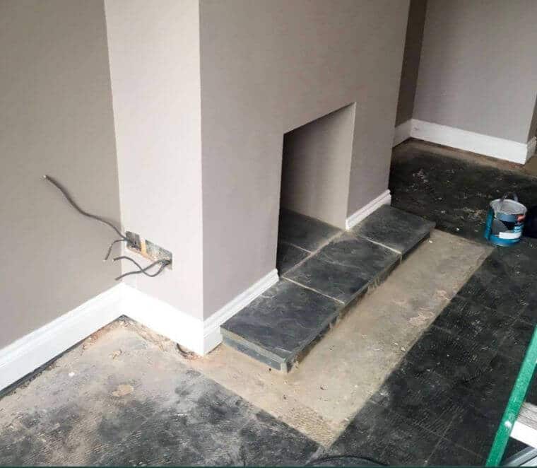 Grey painted walls with white skirting and slate fireplace
