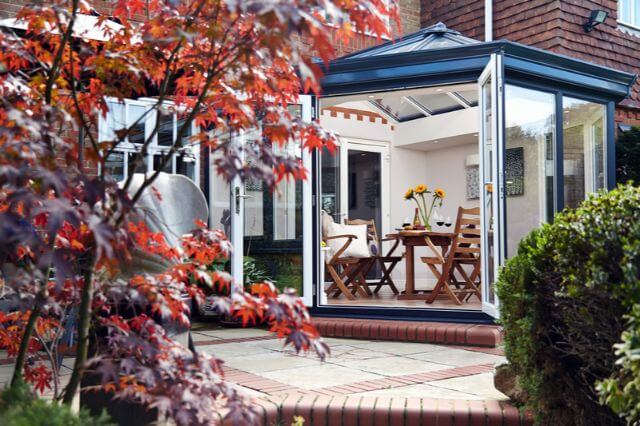 Conservatory with a black roof and bifold doors