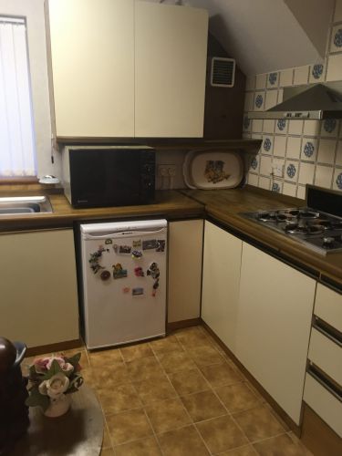 Kitchen before with old units and cream and blue tiles