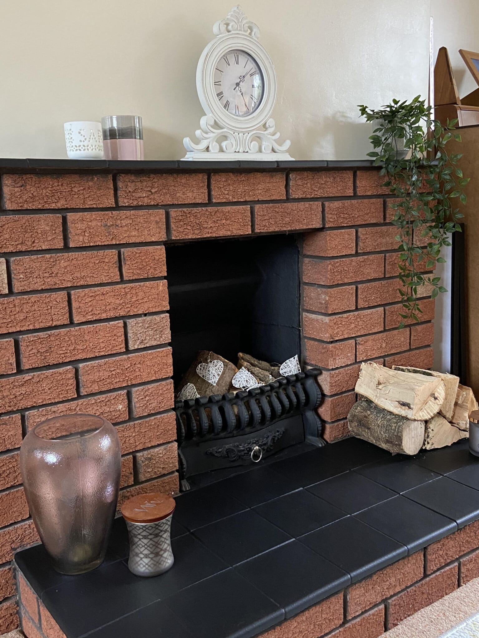 Finished fireplace with black tiles and logs