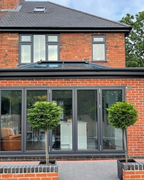 A red brick house that's had the windows and doors sprayed