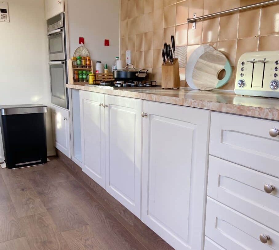 Our finished kitchen with cream/peach units and dark wood floor after the renovation