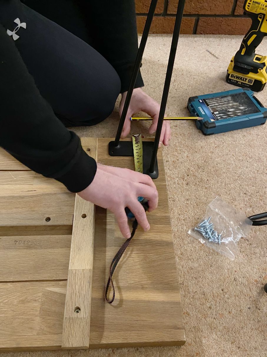 Measuring the legs on the reclaimed wood to make a DIY coffee table
