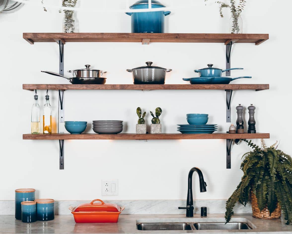 Open shelves in a kitchen with bright dishes and kitchenware on it