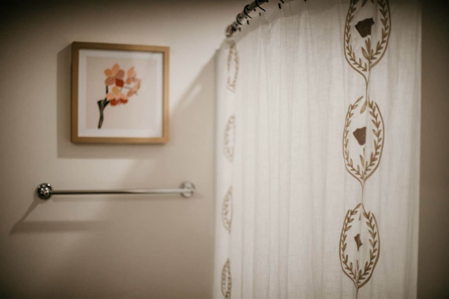 A bathroom with cream walls and a white shower curtain