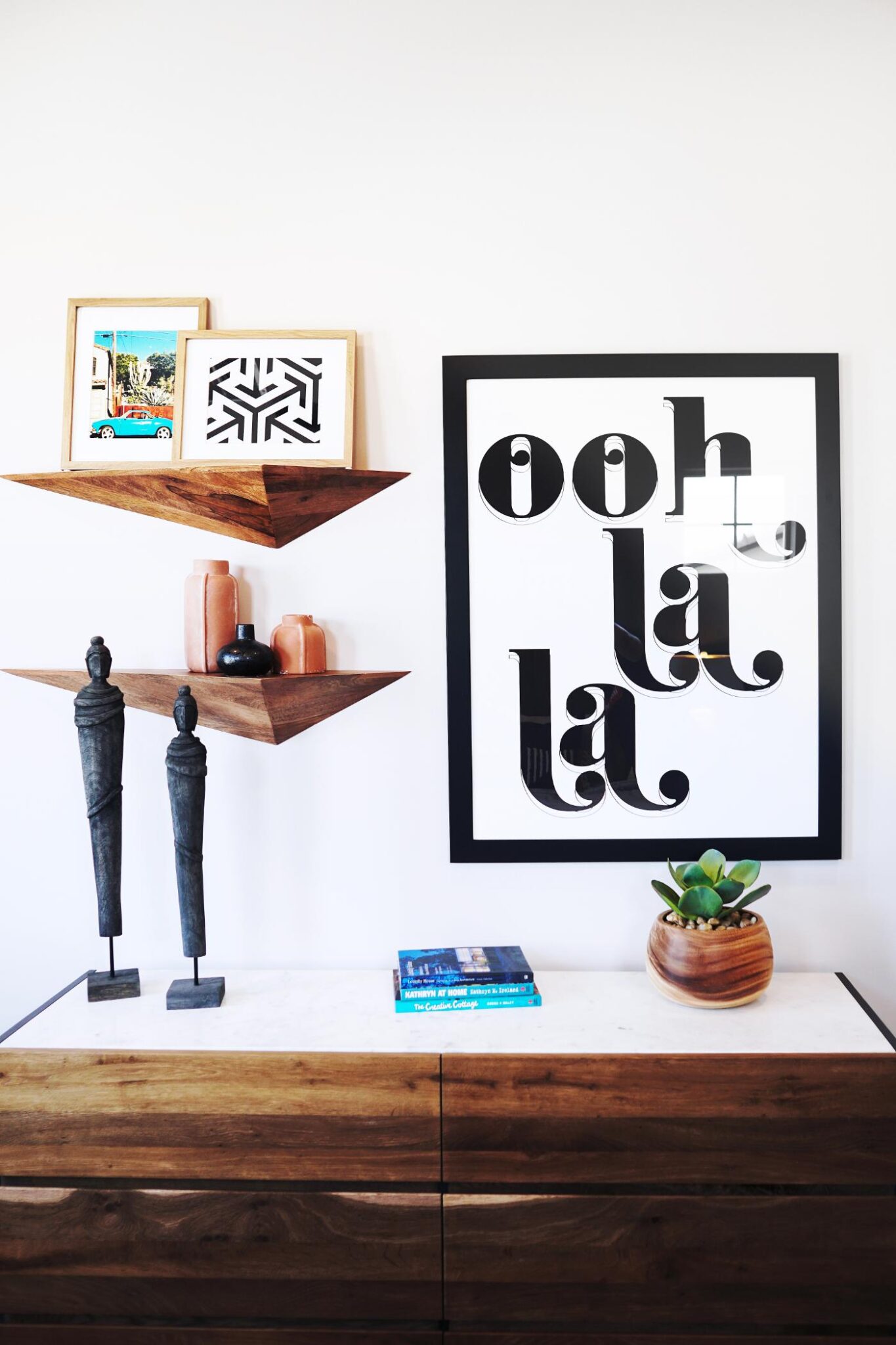 Shelves with artwork resting on them against a white wall