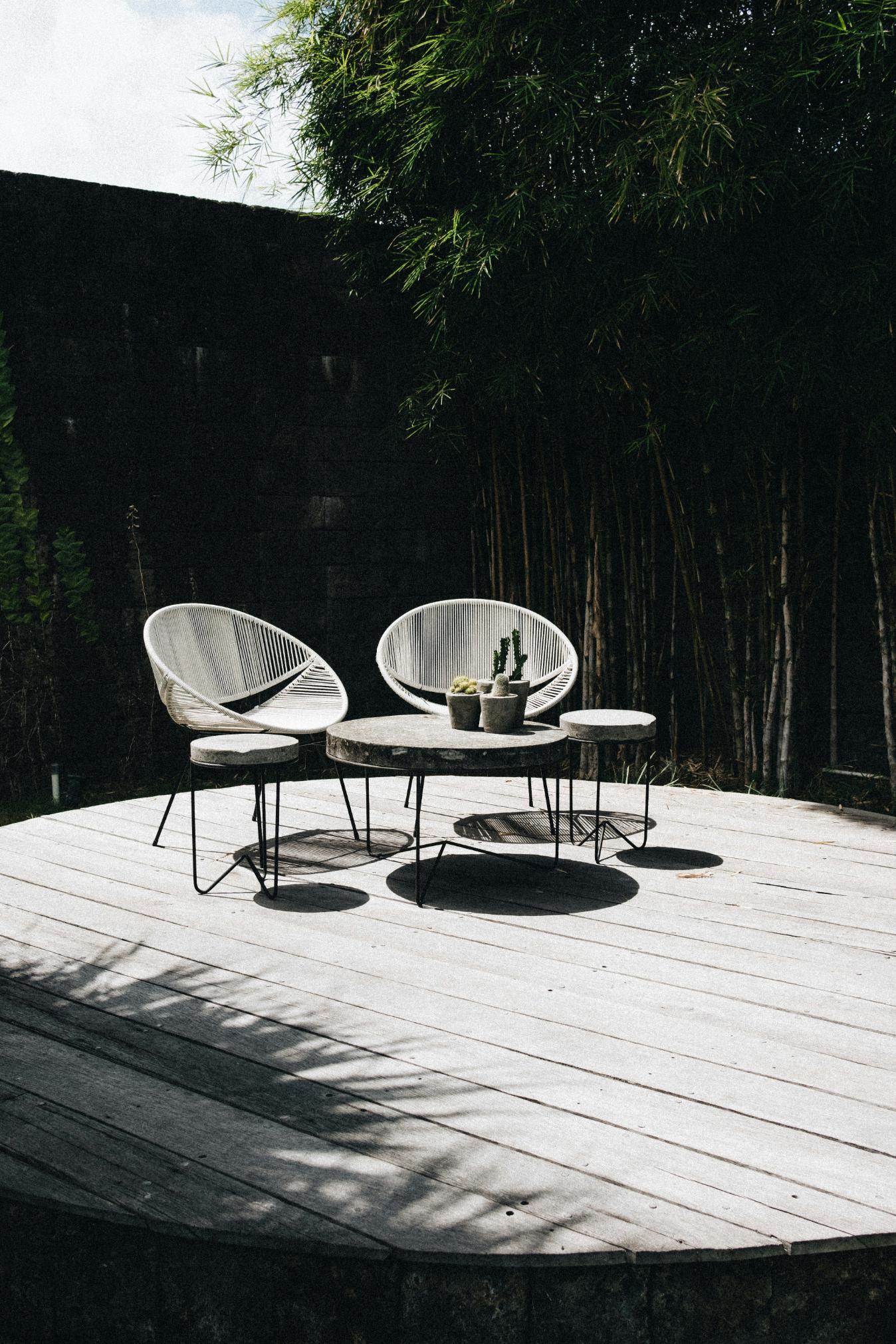 Large decked area with wire chairs and coffee table