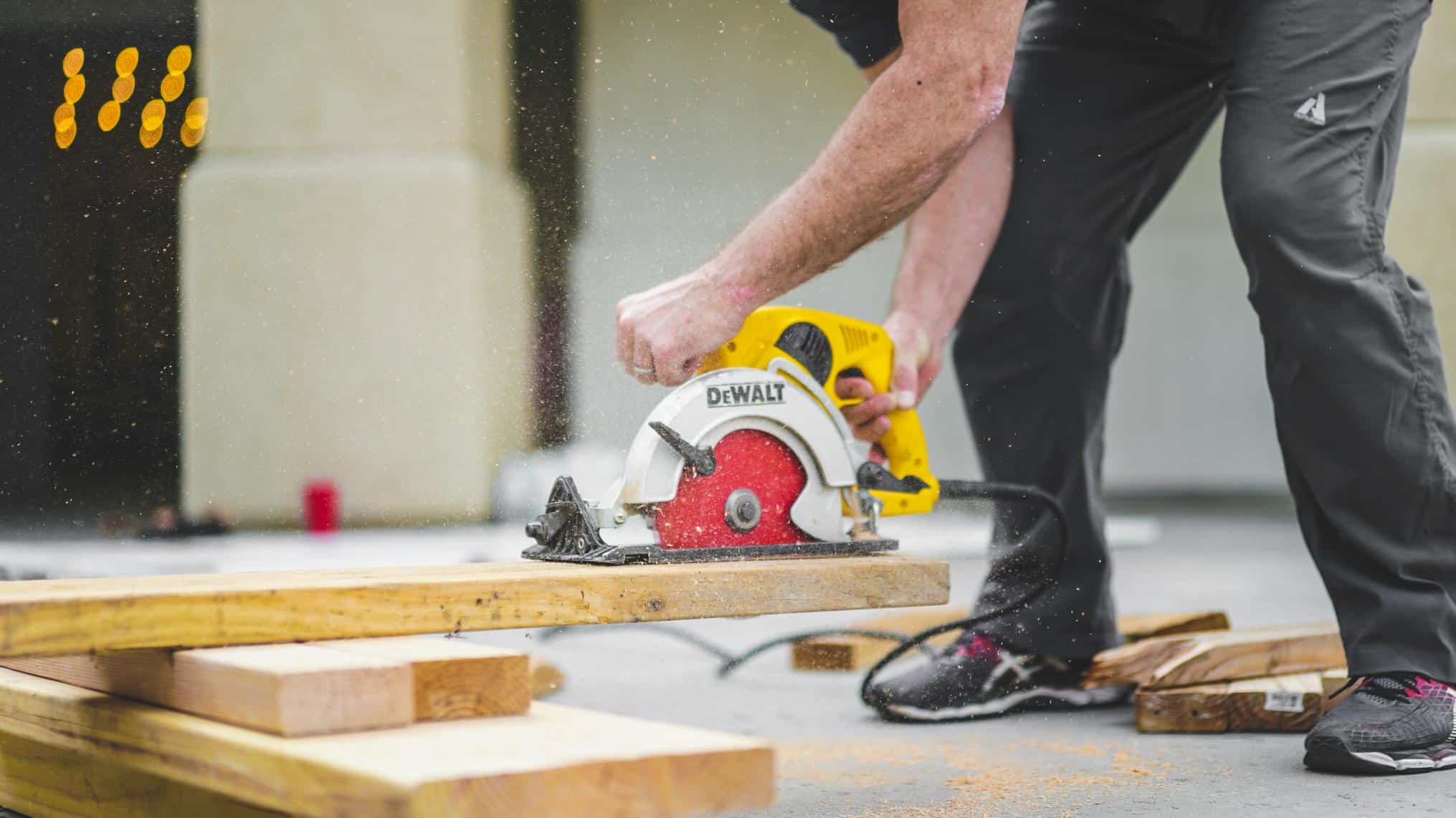 A person using a power saw to cut some wood on a home renovation