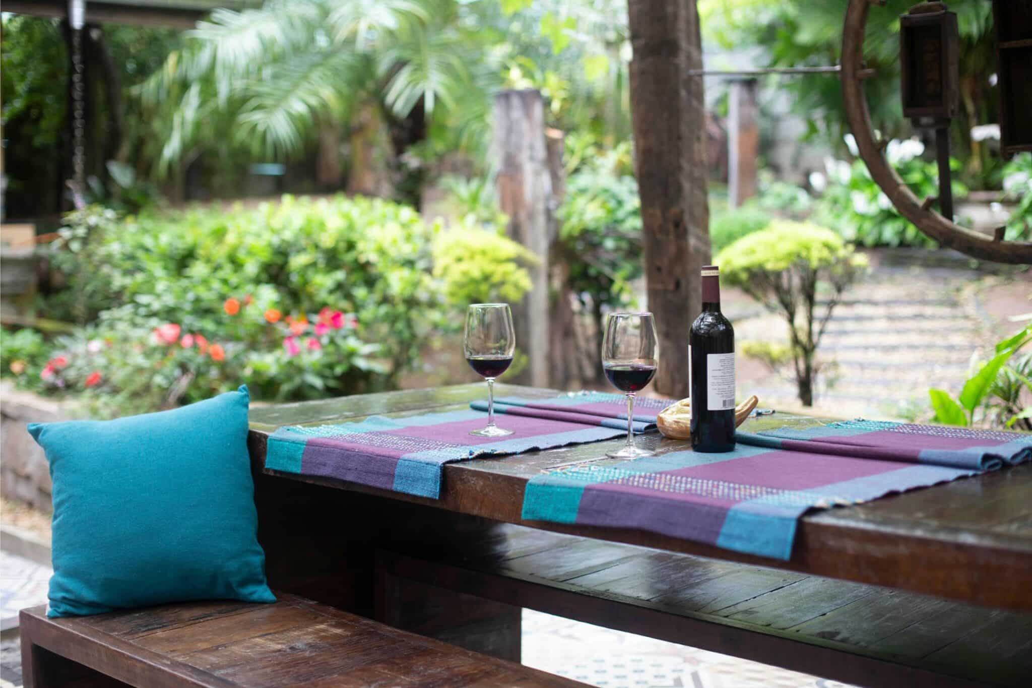 Wine on a table in a garden under a pergola roof in the shade