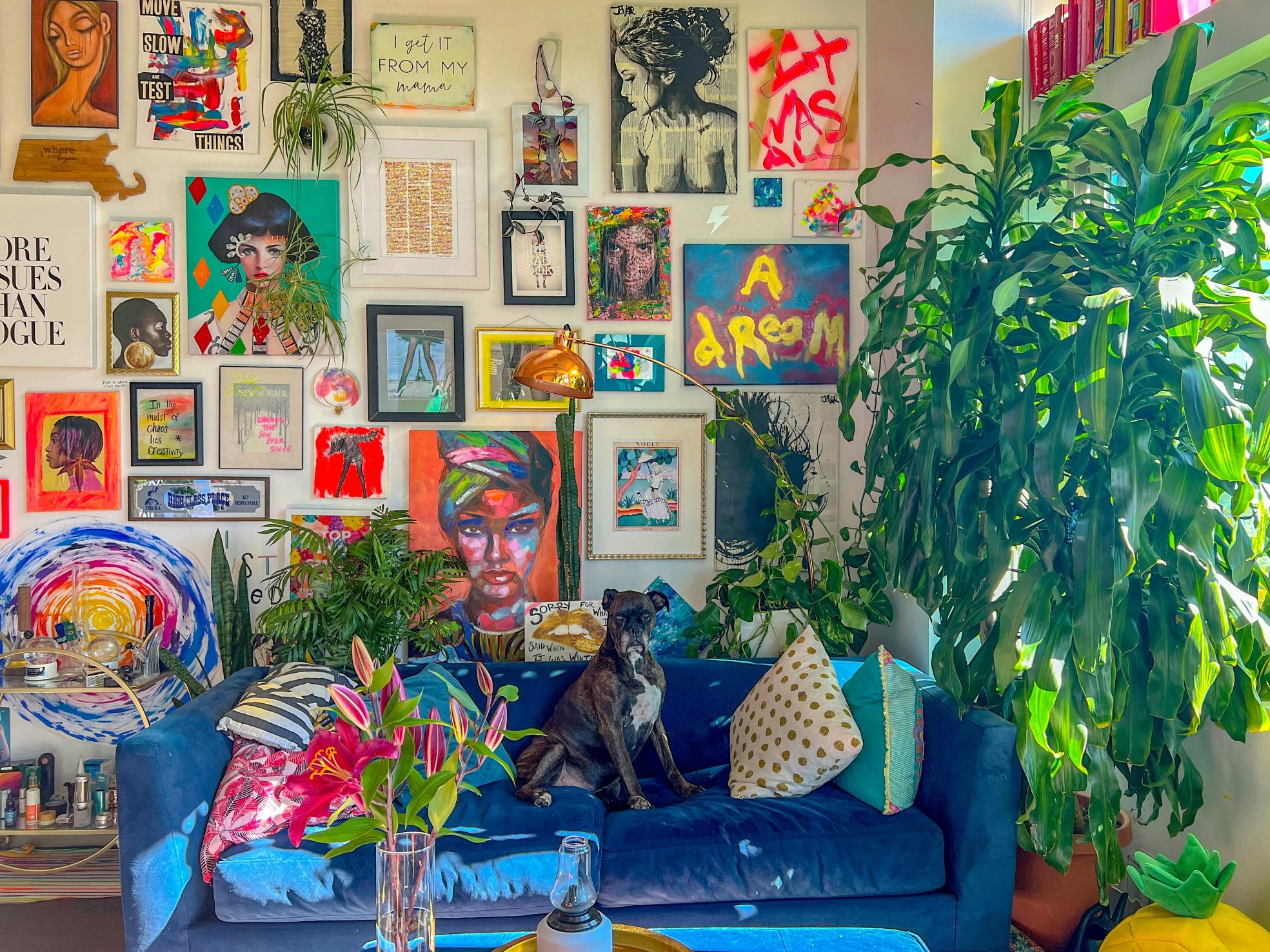 A blue sofa that's covered in bright coloured cushions