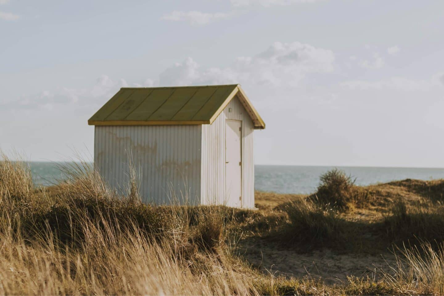 A white shed build on a cliff next to the sea