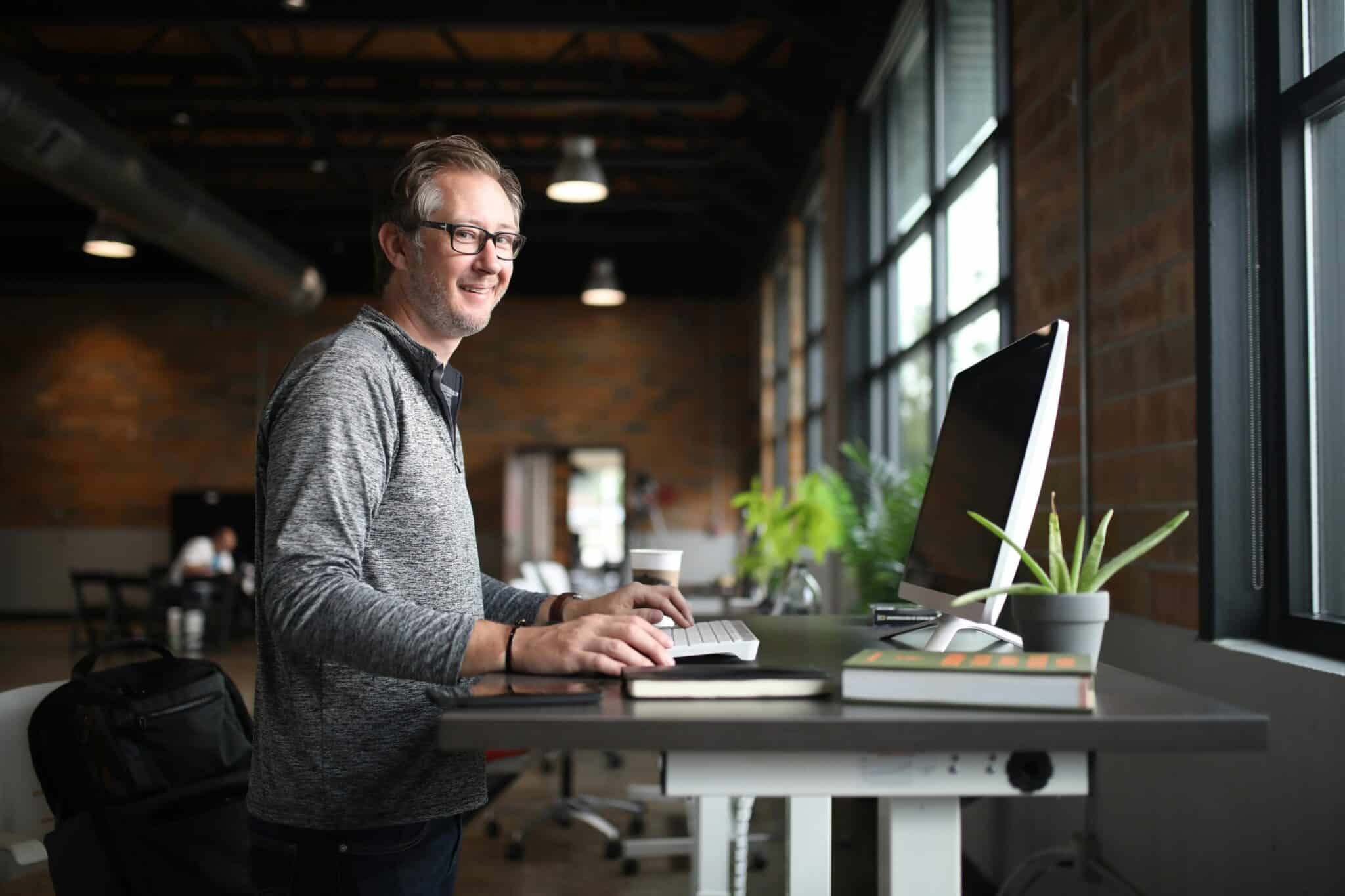 A man working at an ergonomic desk in a modern office