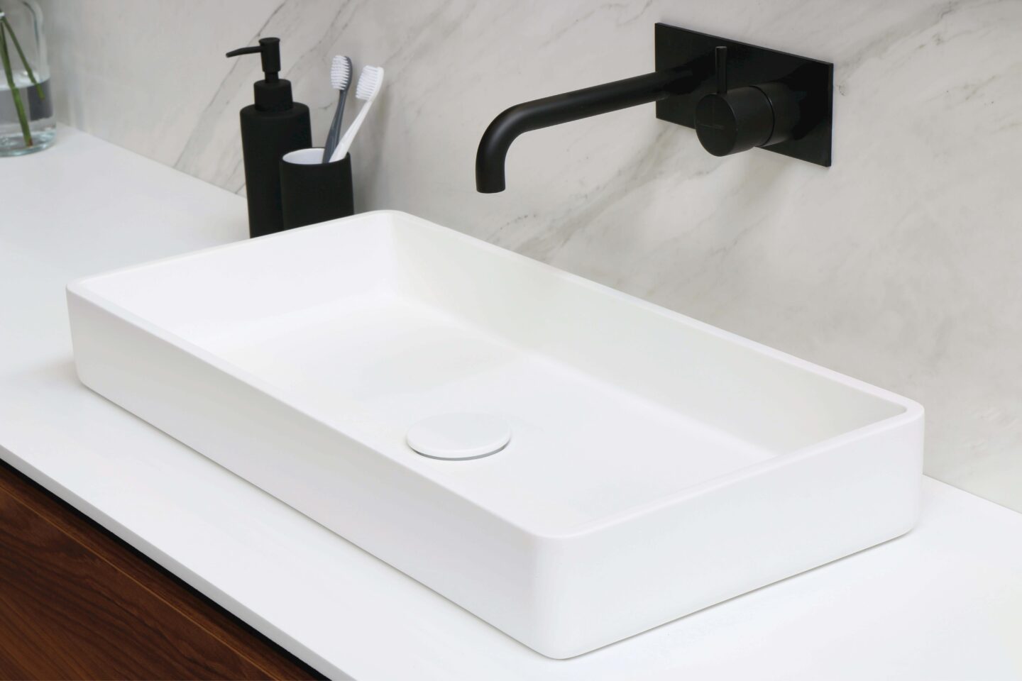 A matte black kitchen tap over a modern square sink
