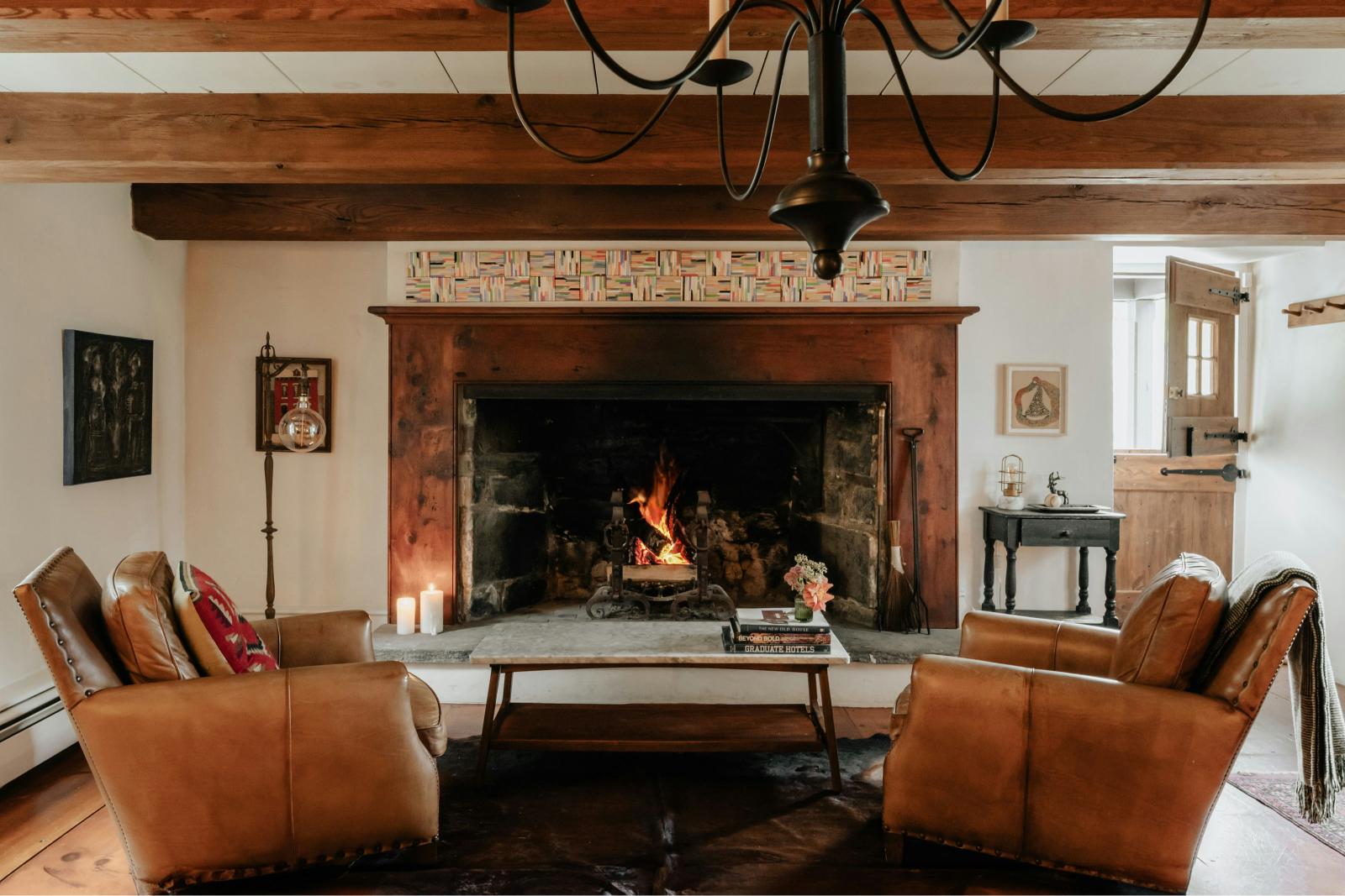 A very large inglebook fireplace with a stone hearth in a beautiful cottage