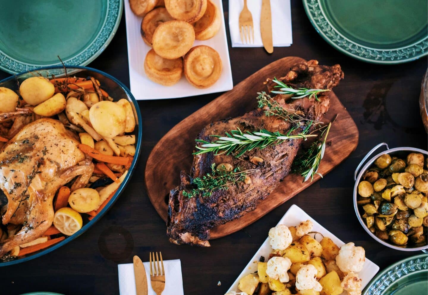 A Christmas lunch laid out on the table with lamb, potatoes and vegetables
