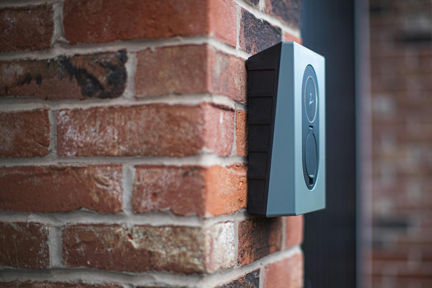 A smart doorbell installed on the brick wall of an old UK house