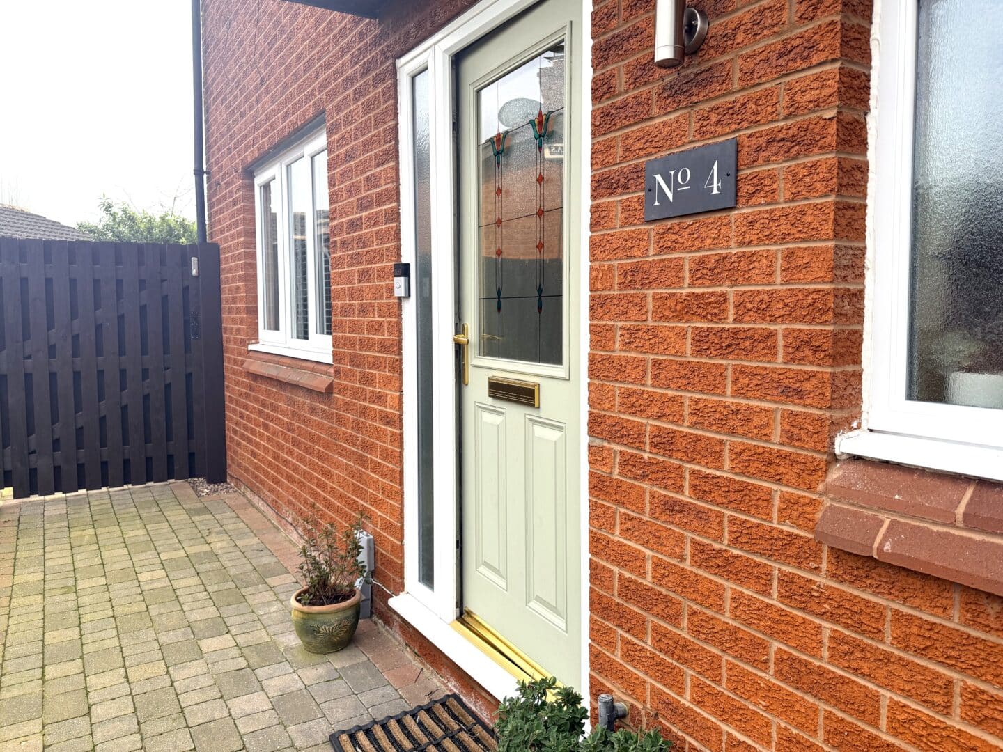 Our front door in sage green with a new front door light and house sign