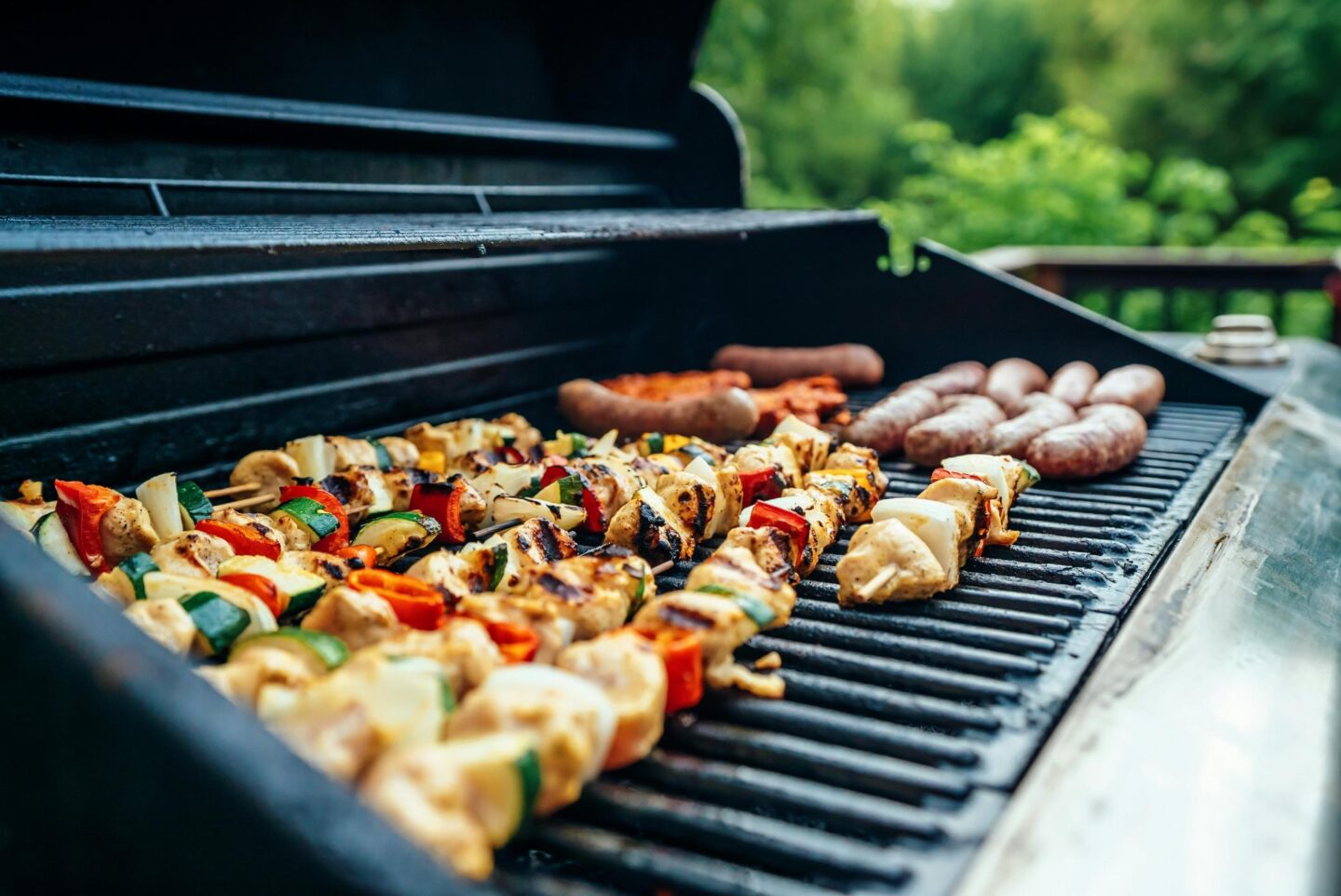 Kebabs lined up on a barbeque with coals underneath