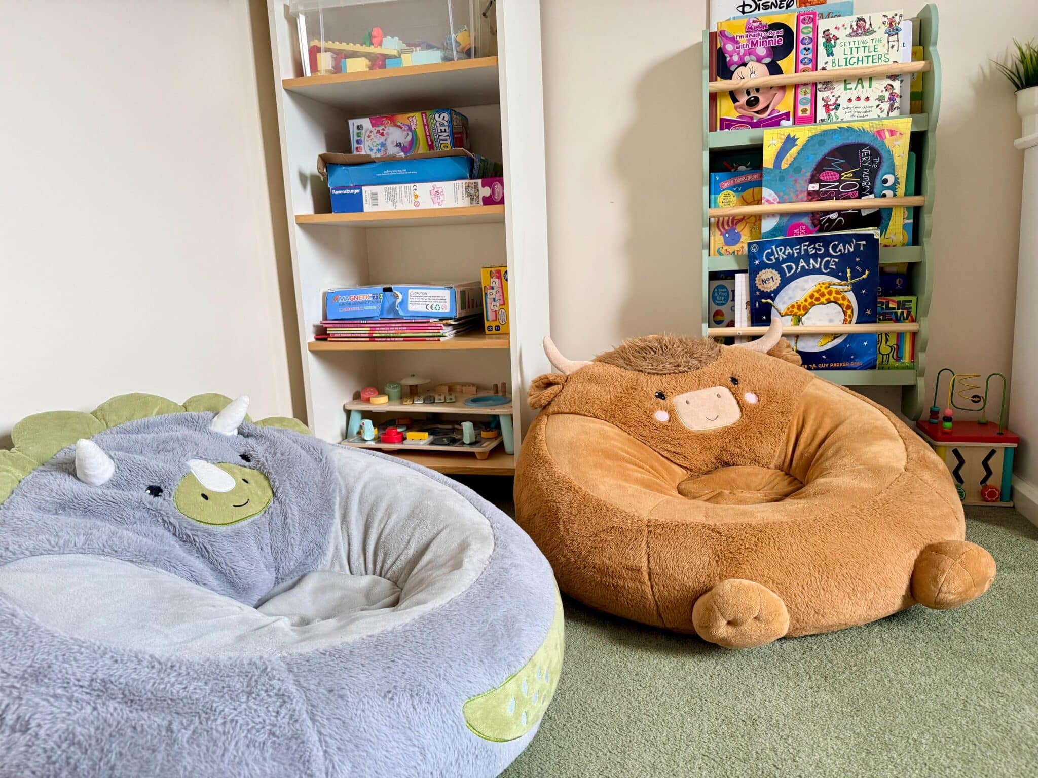 Our playroom with storage and a highland cow and dinosaur seat cushion for reading on